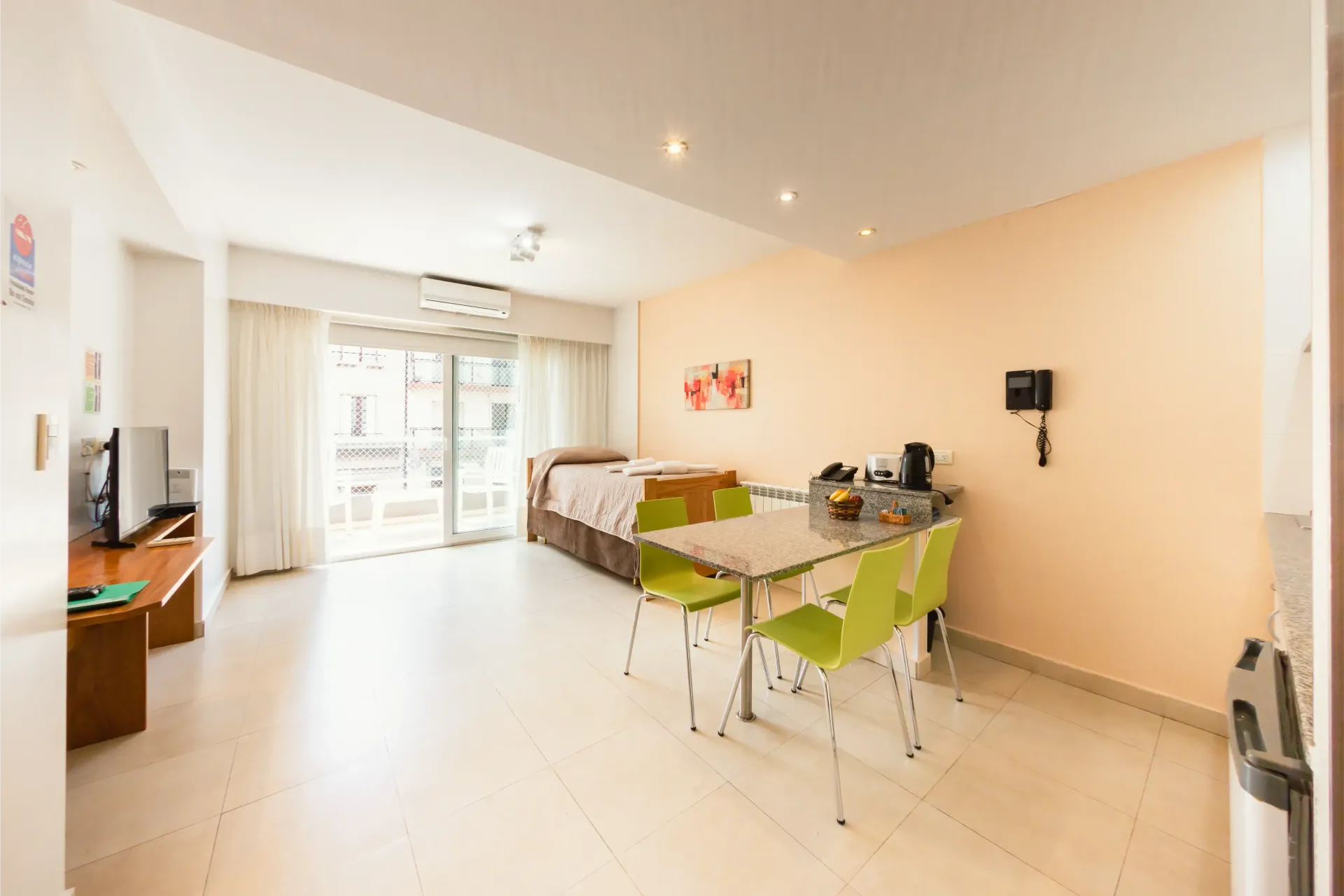 Una sala de estar con una mesa y sillas y una cama.