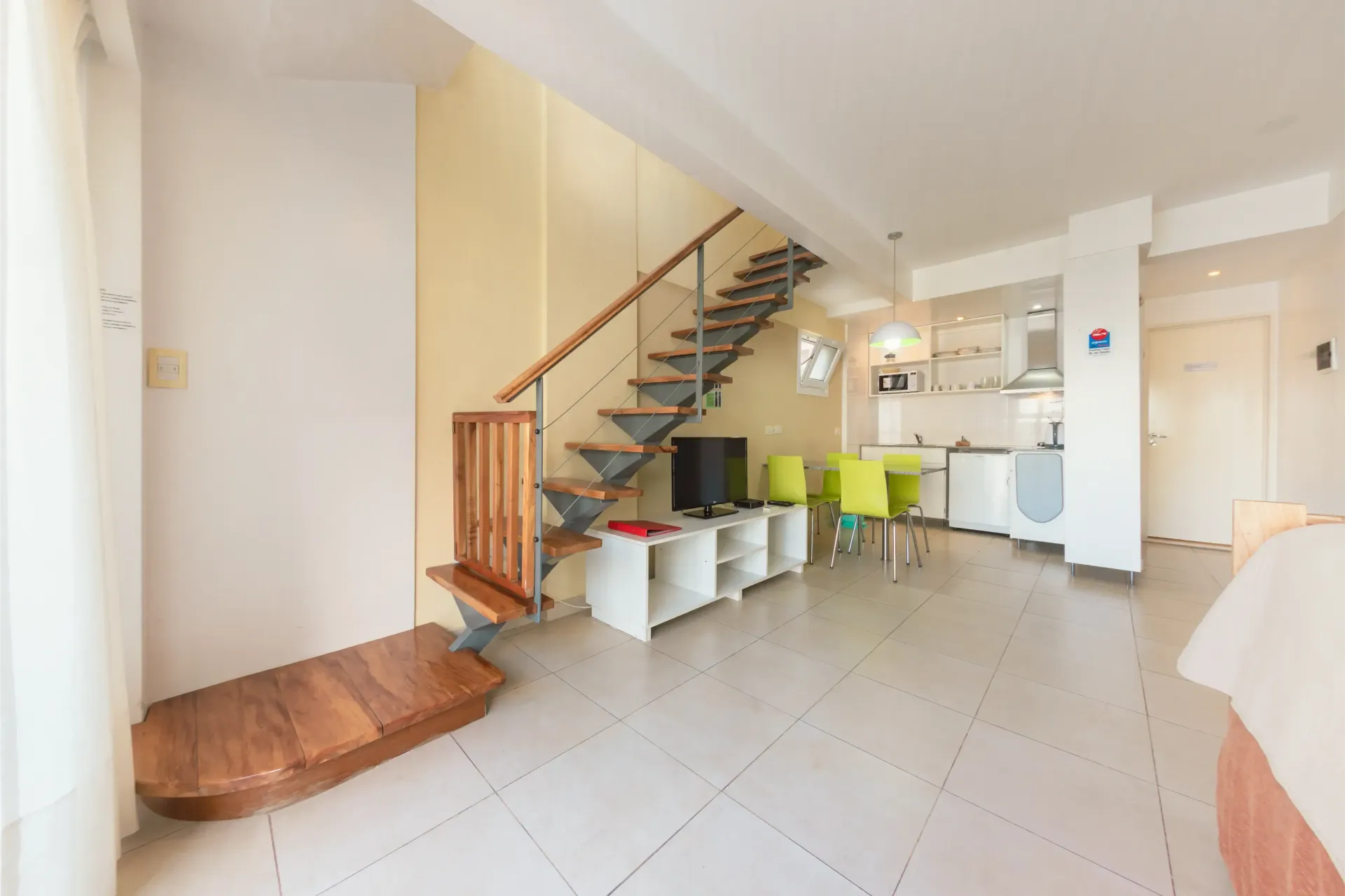 Una sala de estar con una escalera de caracol que conduce al segundo piso.