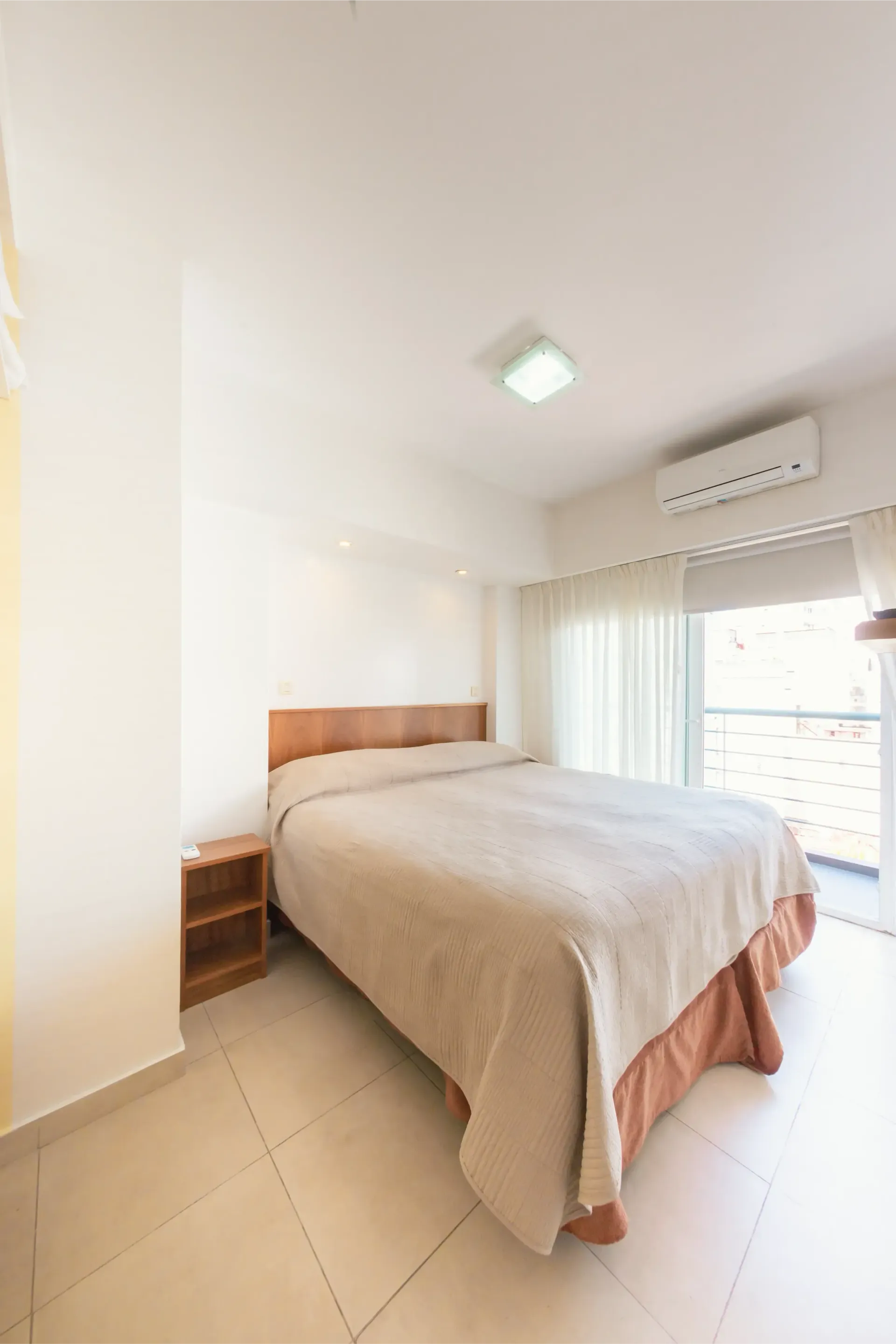 Un dormitorio con una cama grande y un balcón.