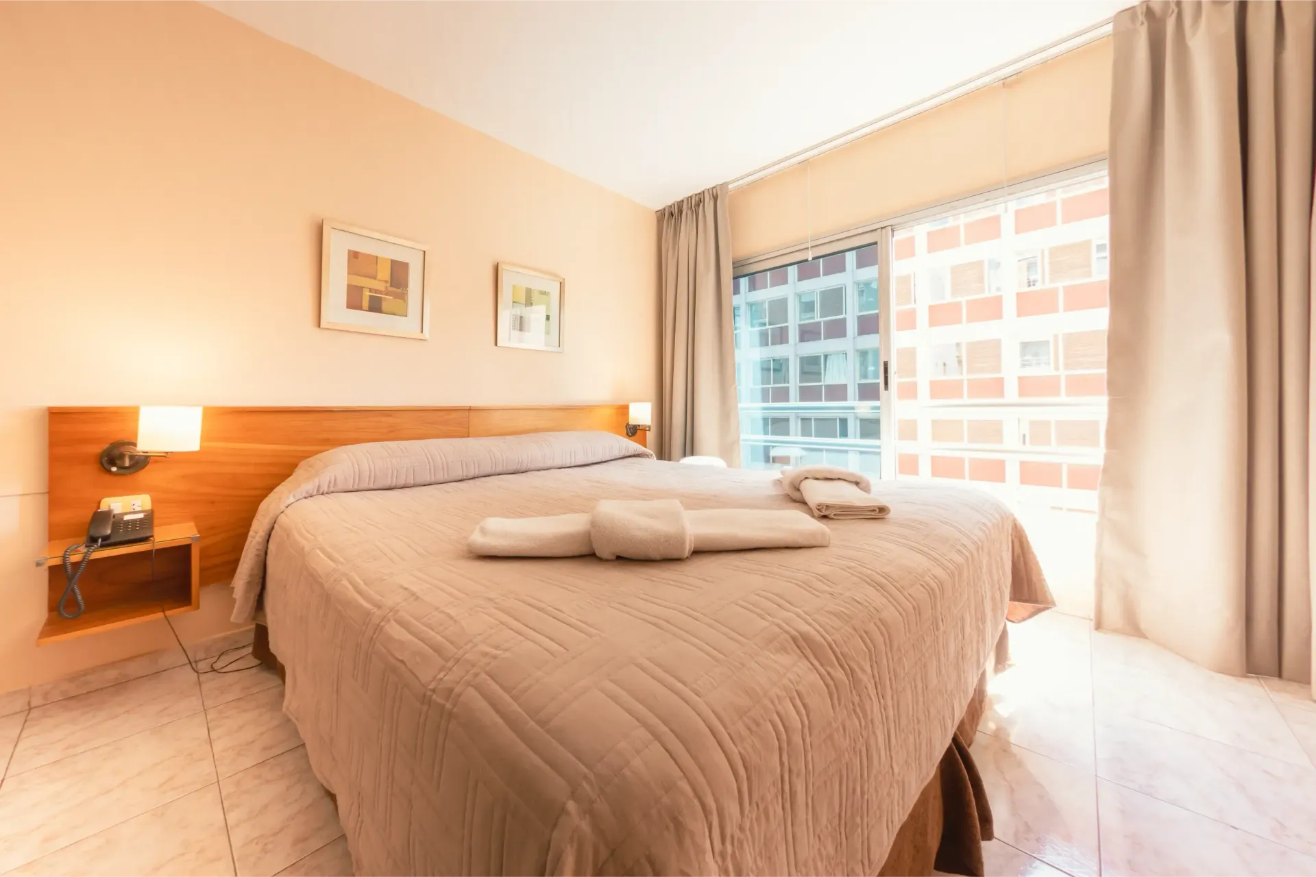 Una habitación de hotel con una cama grande y una ventana grande.