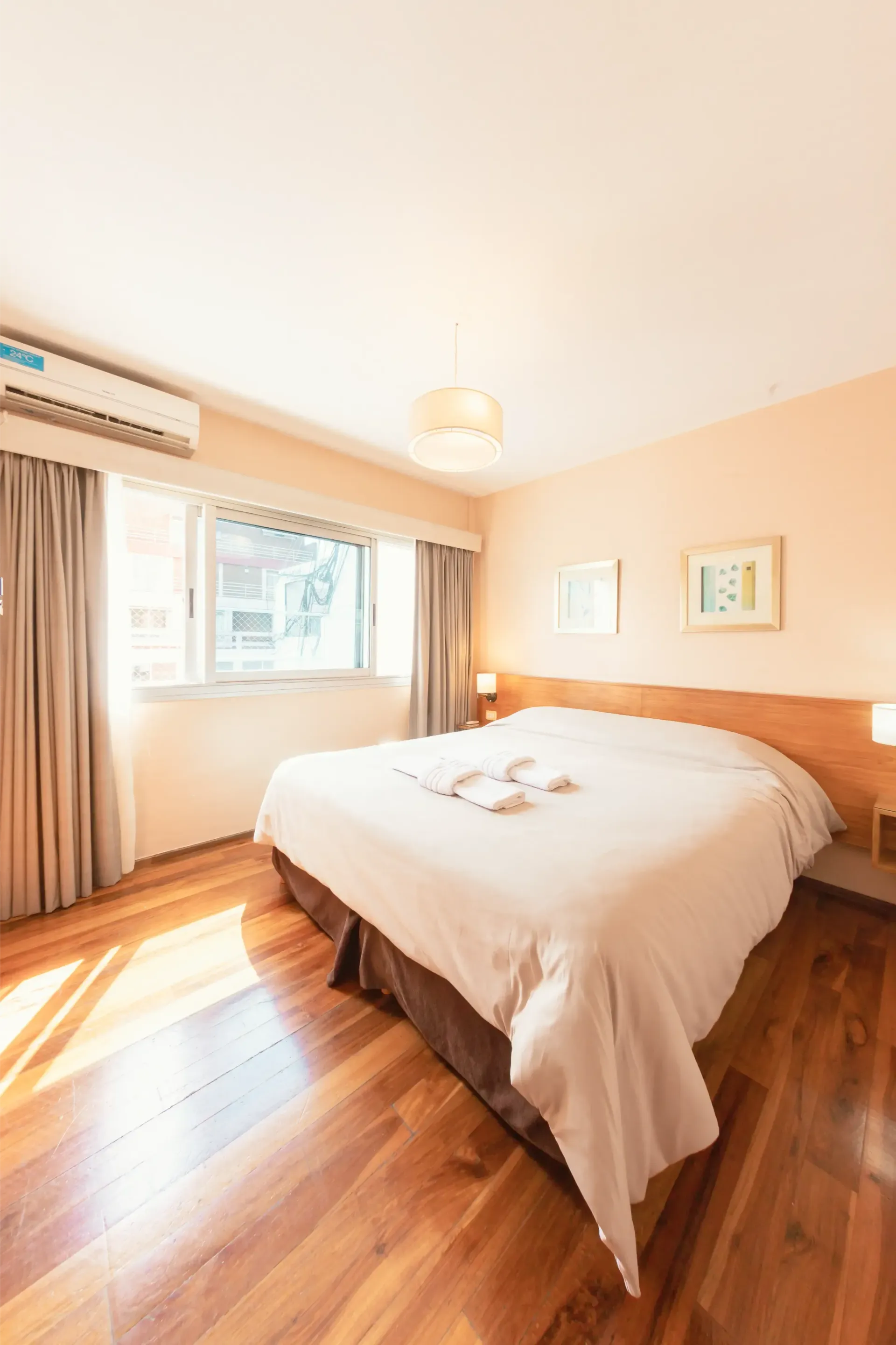 Una habitación de hotel con una cama tamaño king y pisos de madera.