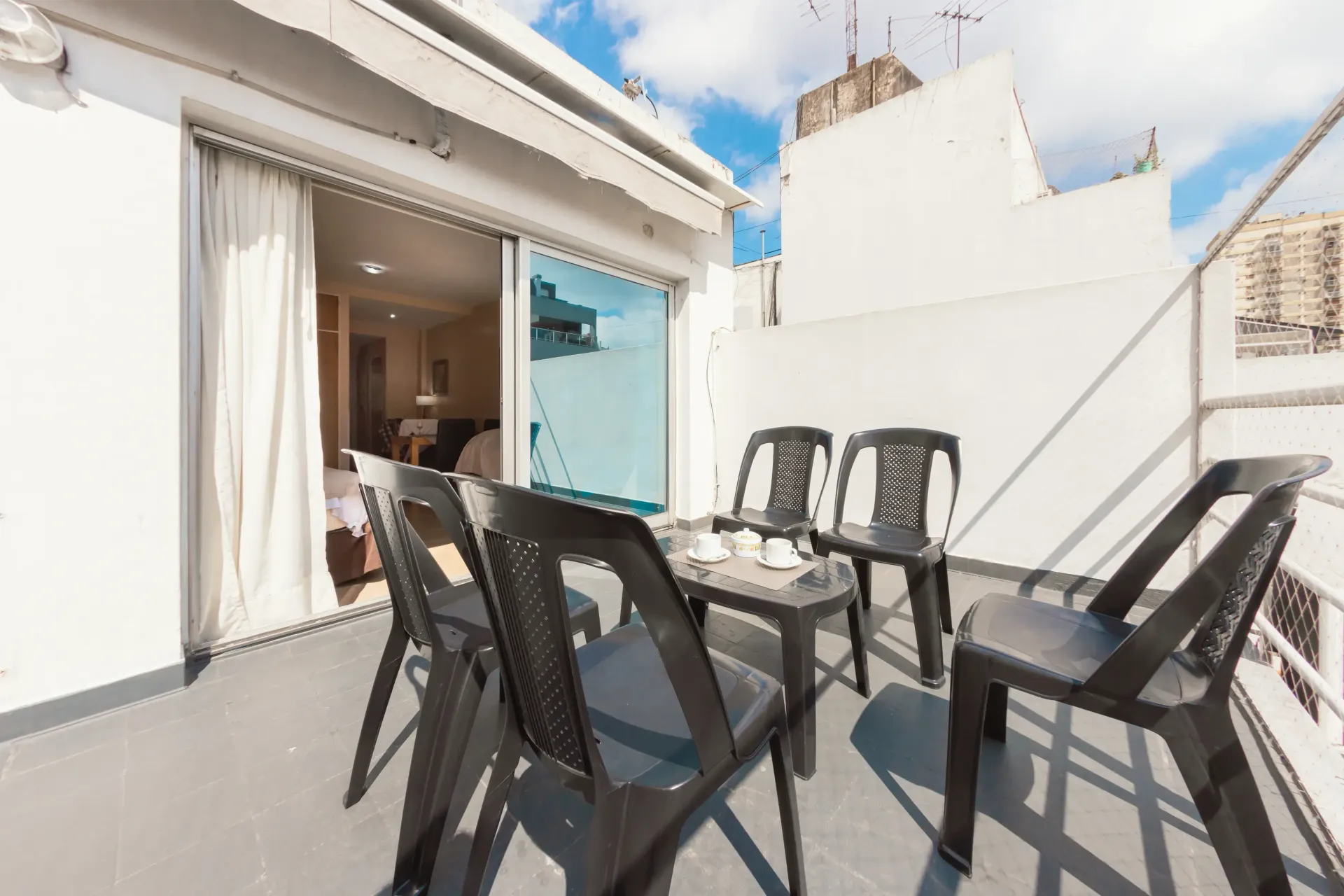 Un balcón con una mesa y sillas.