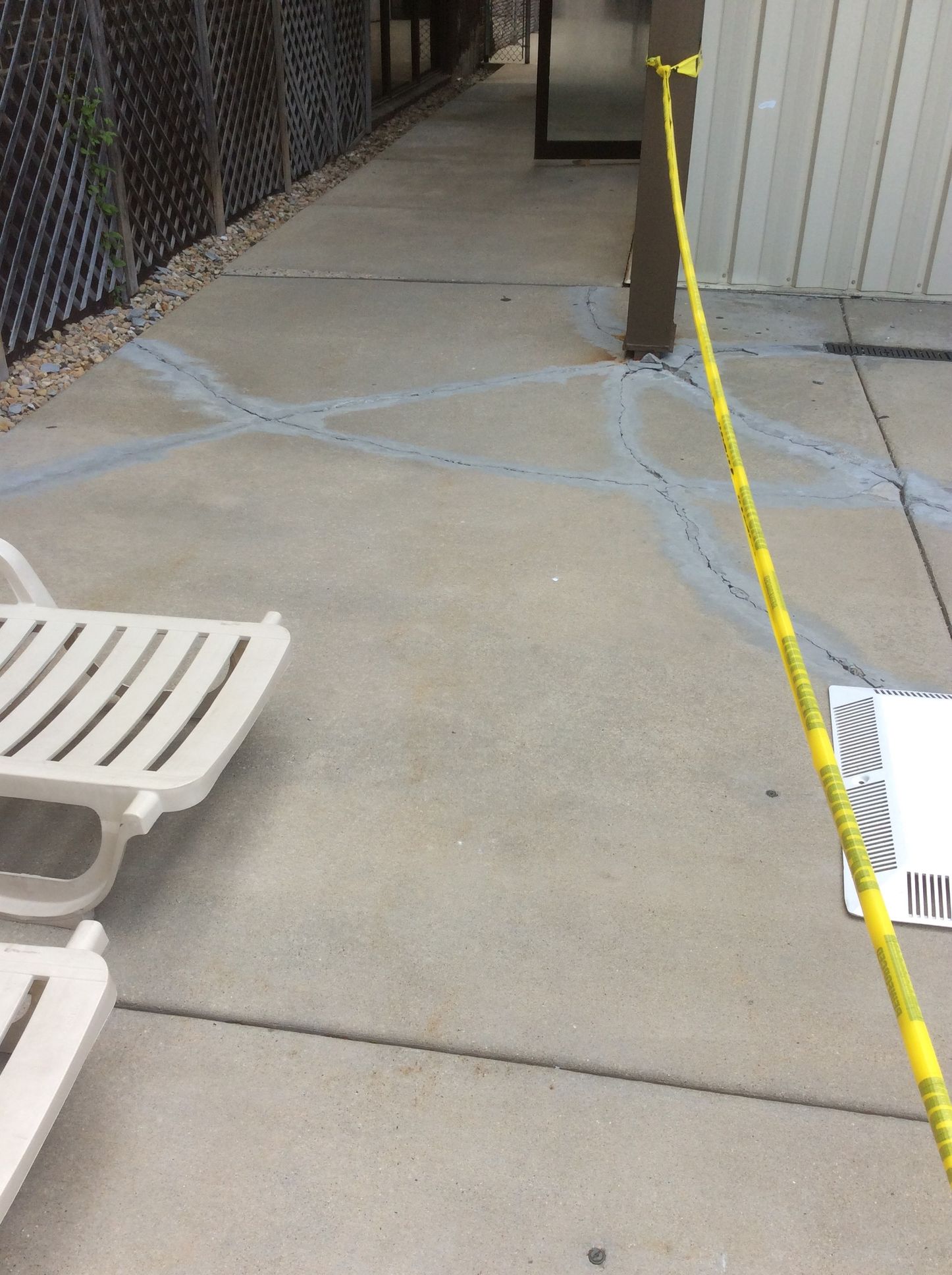 A yellow caution tape is hanging from a chain link fence