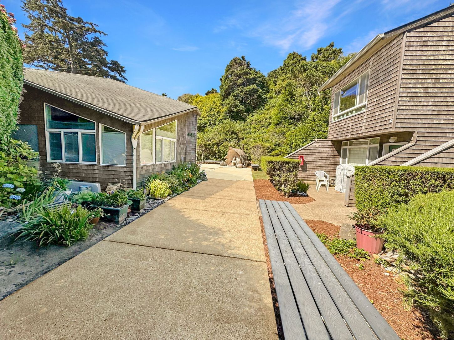 A path leading to a house with a bench in the middle of it.