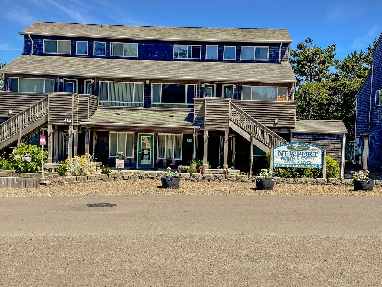 A large building with stairs leading up to it is sitting on the side of the road.