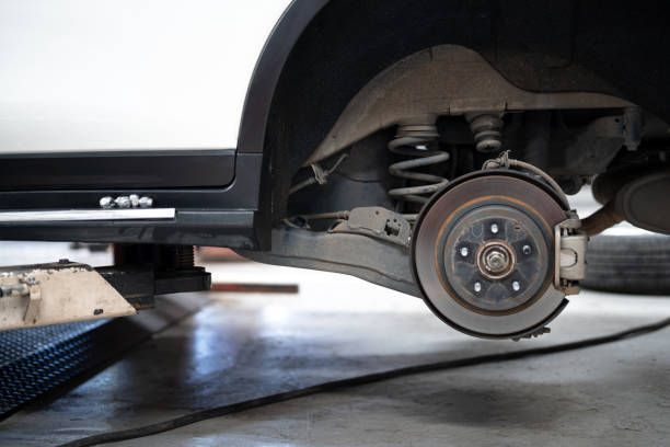 A Close up Of a Car 's Rear Wheel on A Lift.
