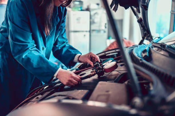 A Woman Is Working on A Car in A Garage.