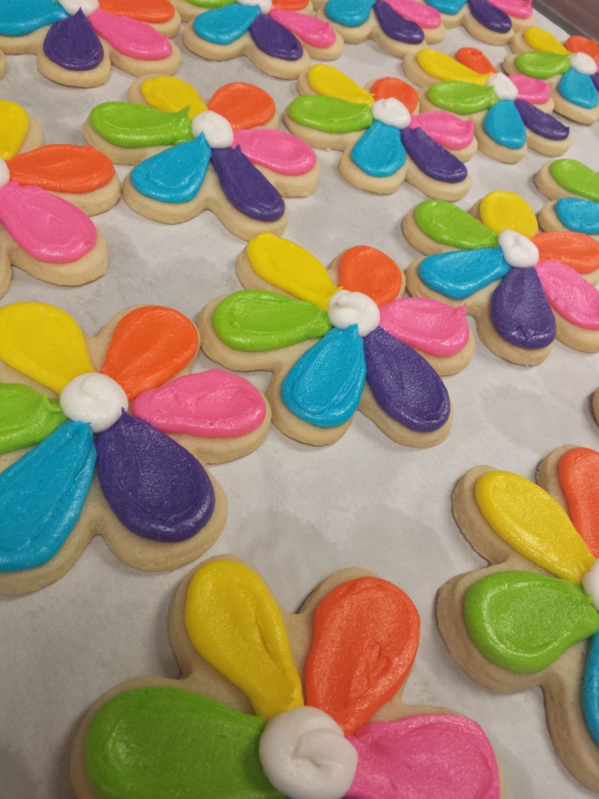 A tray of sugar cookies shaped likemulticolored flowers