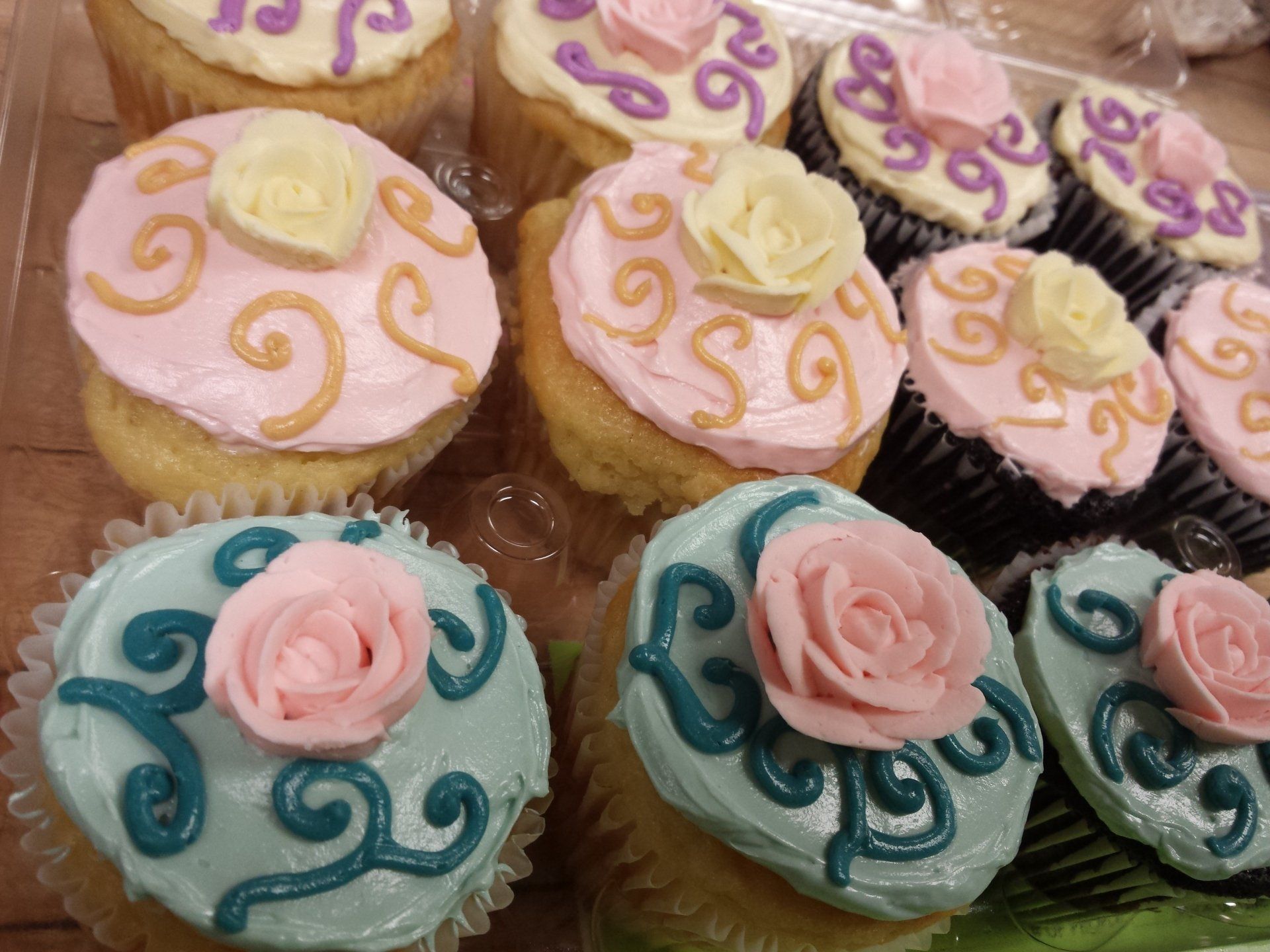 Cupcakes with pink and blue icing, with swirl and rose decorations