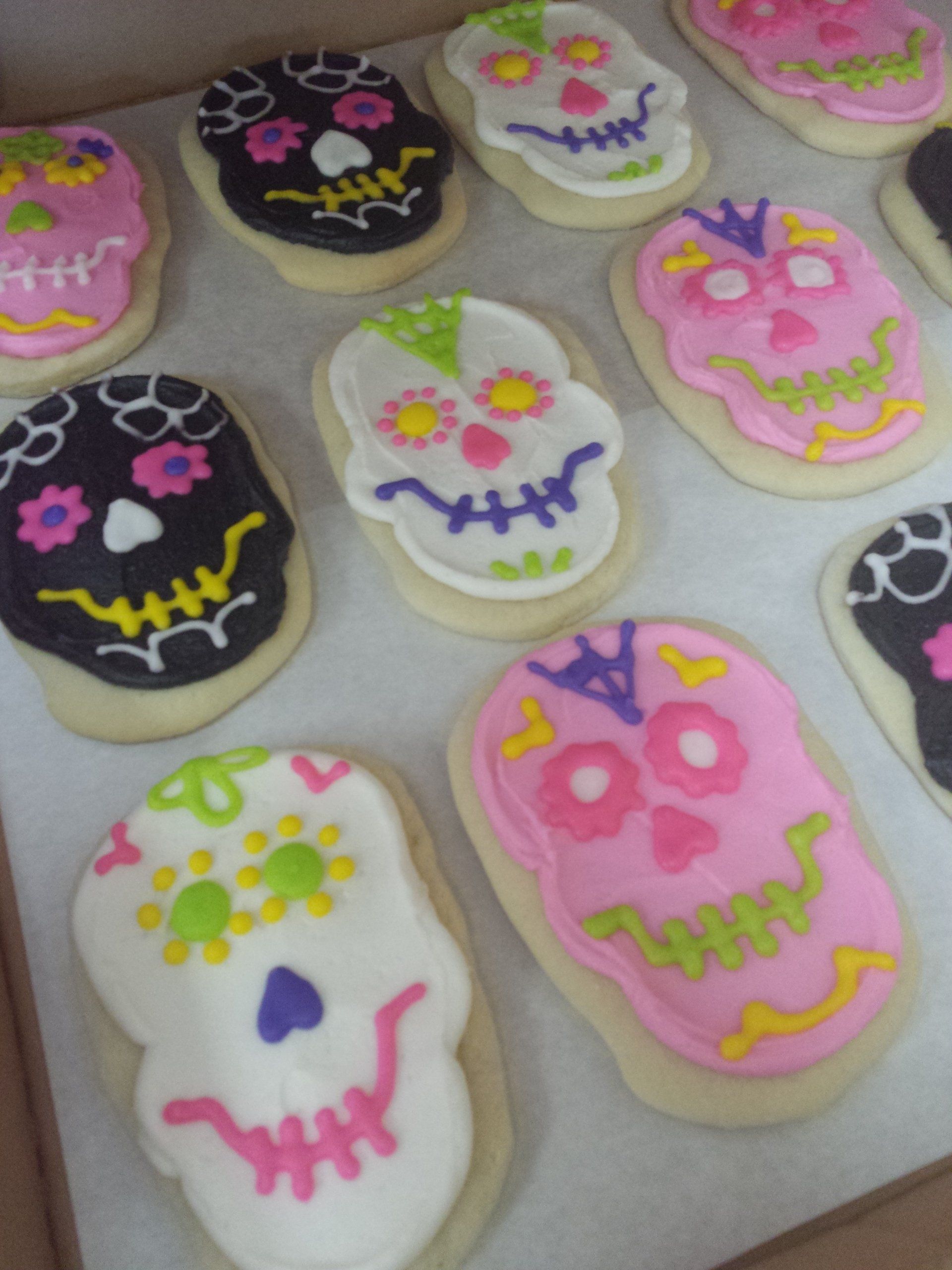 A tray of sugar cookies shaped and iced like sugar skulls