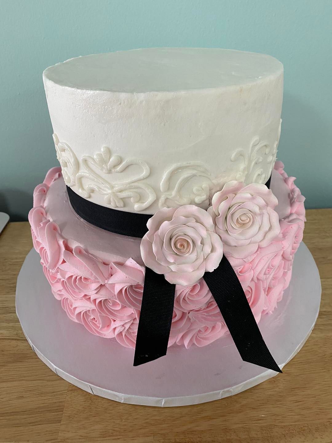 Wedding cake with swirled icing roses in white and pink, dusted with edible glitter