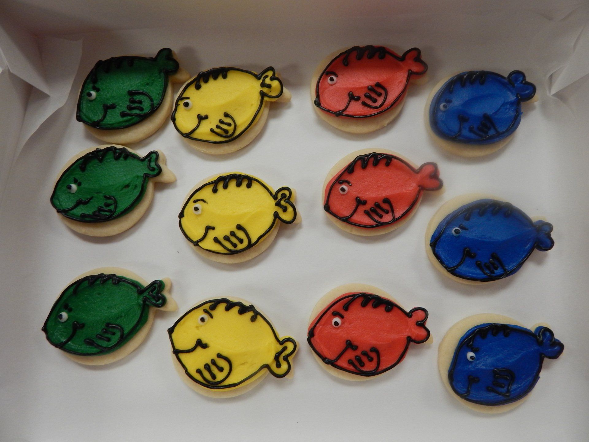 A tray of sugar cookies shaped and iced like Dr Seuss fish