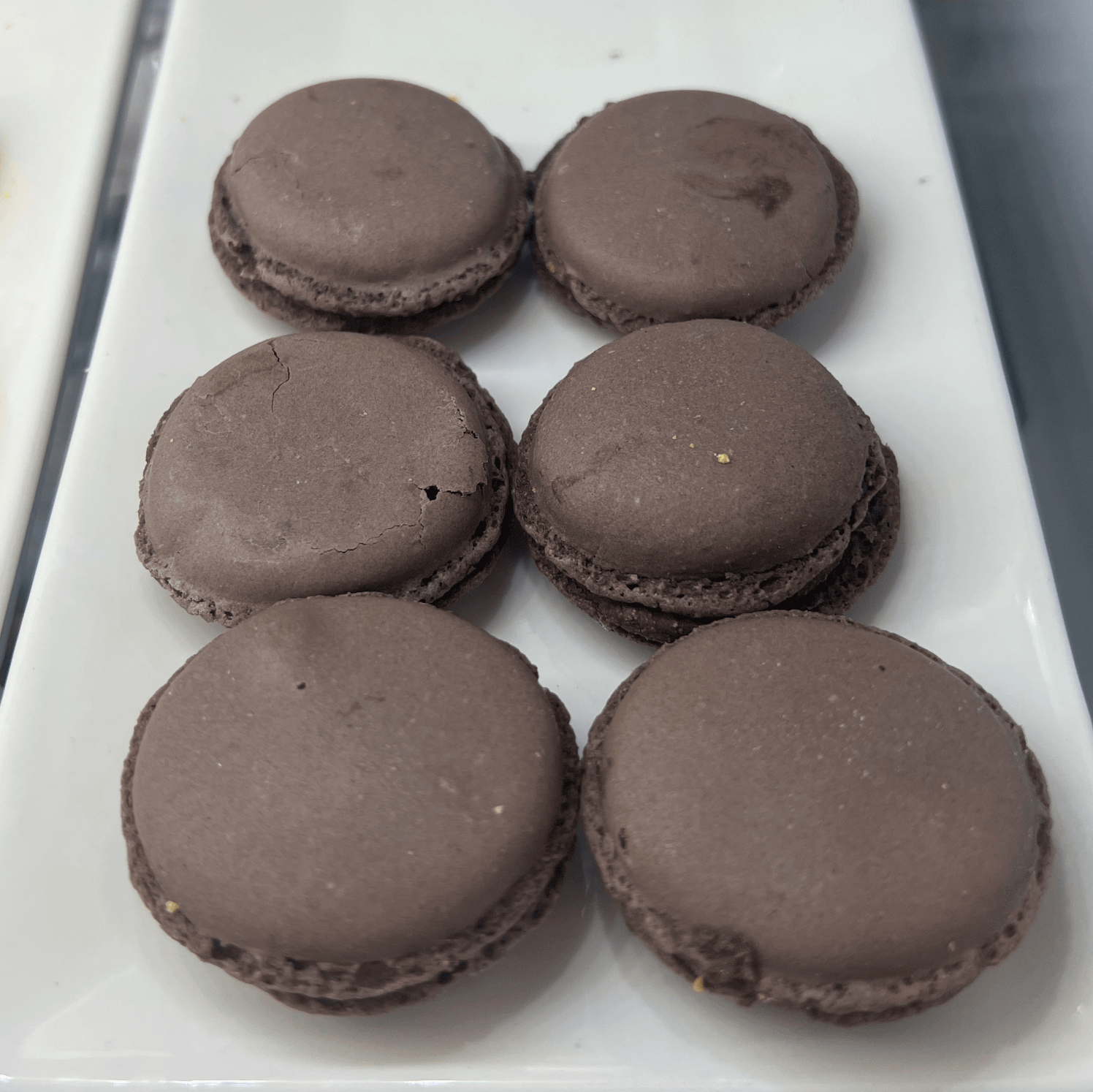 Six chocolate macarons