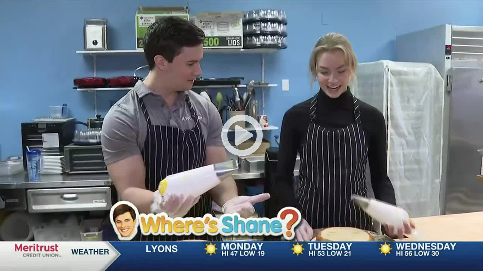A screenshot of a news broadcast interview with Shane from KWCH and Lauren from River City Sweet Shop, holding icing bags