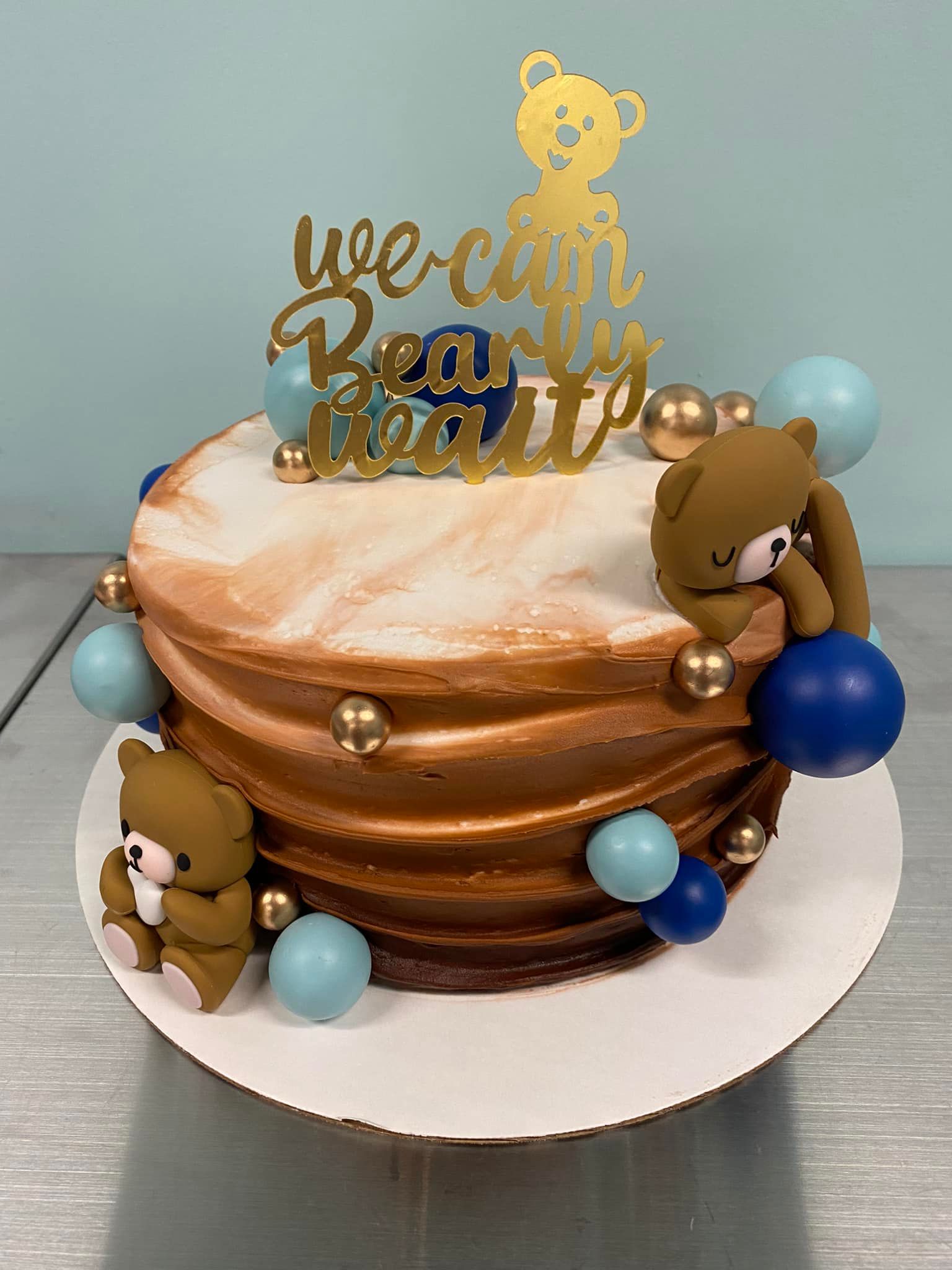 cake decorated with swirls, balls, and teddy bears