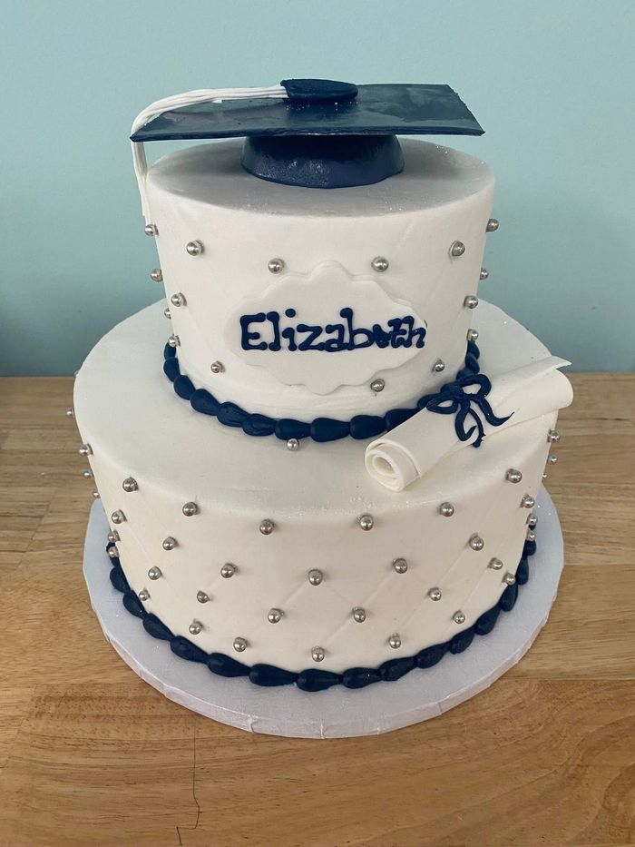tiered cake with a graduation cap decoration