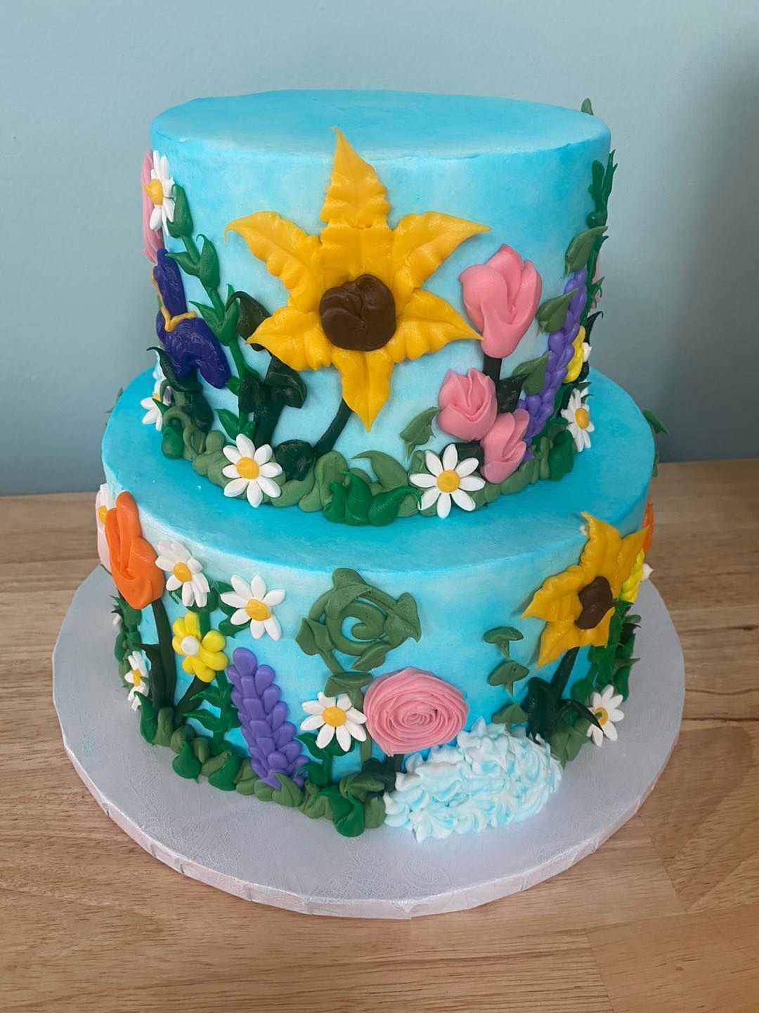 blue iced cake with colorful iced flowers