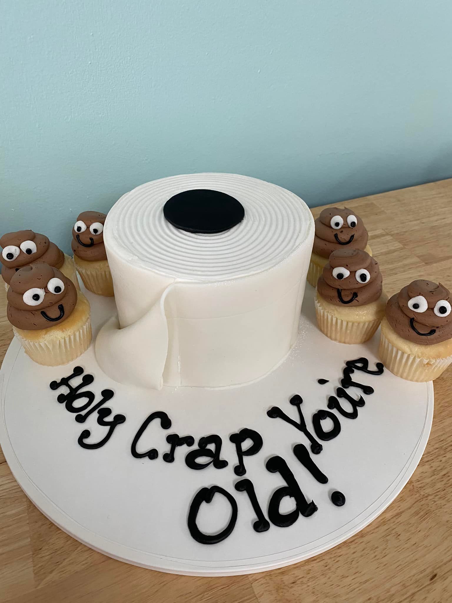 toilet paper shaped cake with smiling poo cupcakes