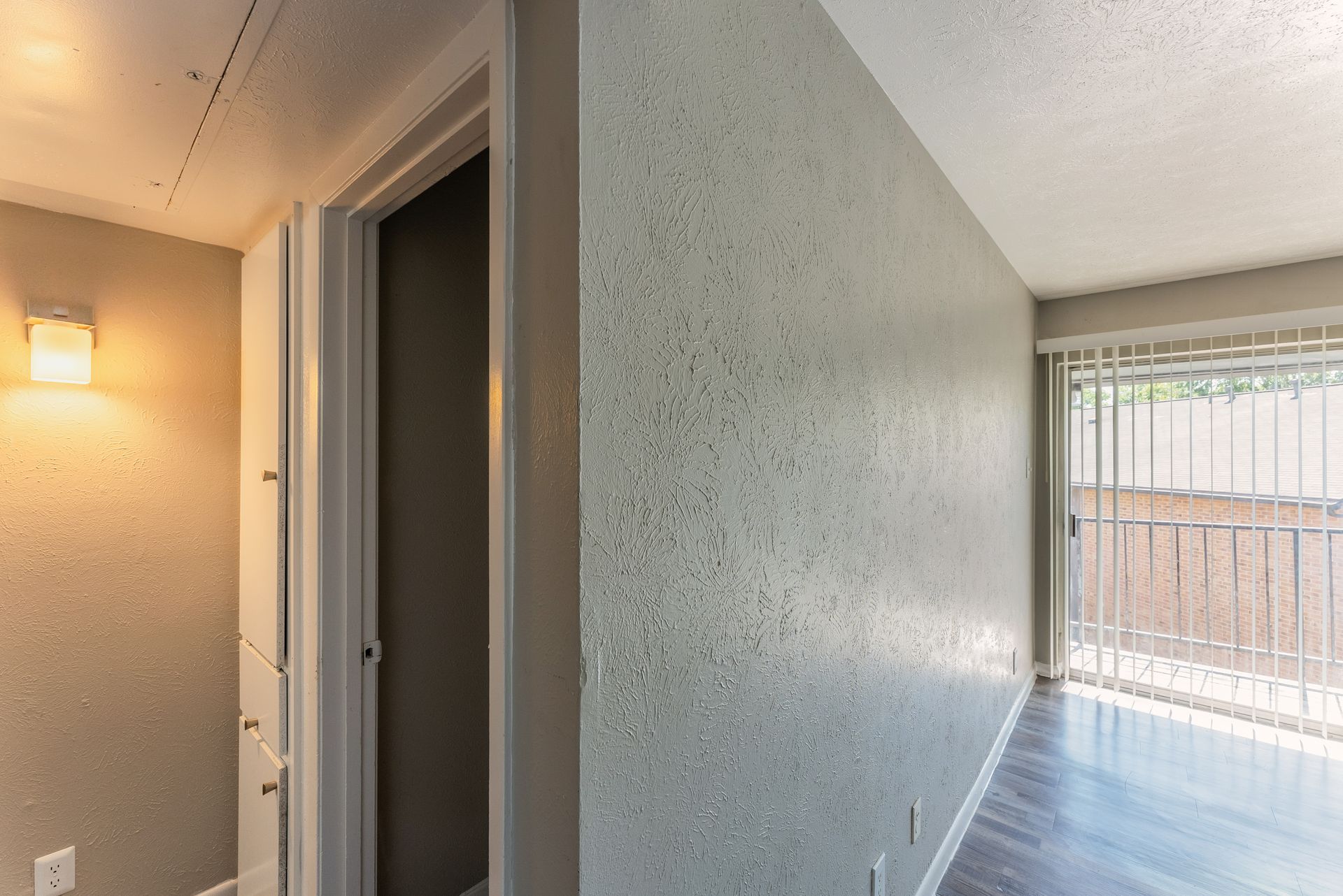 A hallway with a sliding glass door leading to a living room.