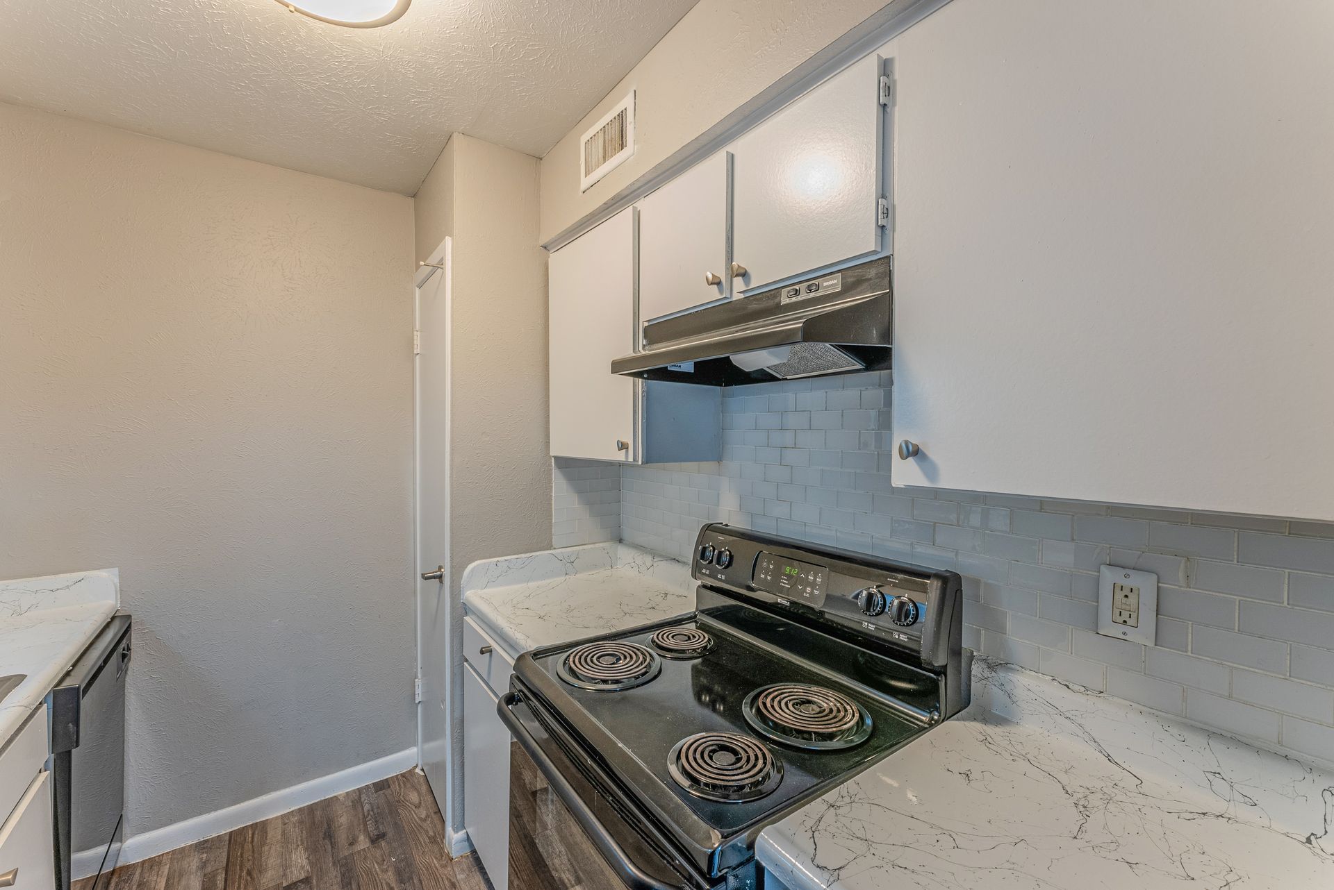 A kitchen with a stove , dishwasher , and counter tops.