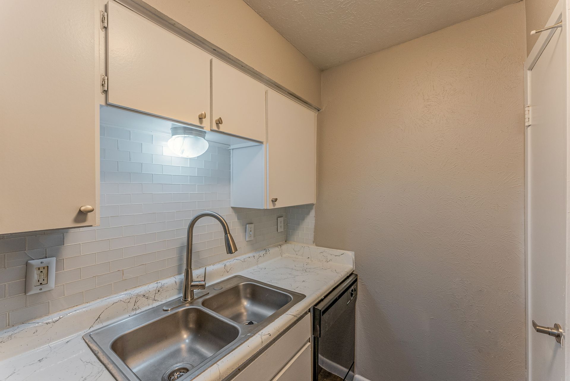 A kitchen with a sink , faucet , and dishwasher.