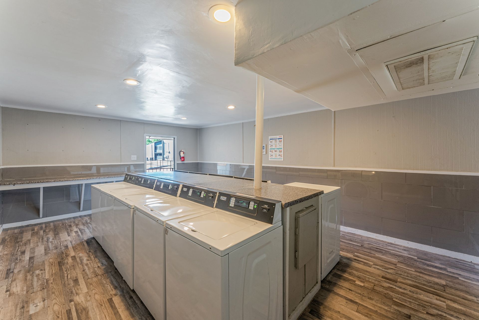 A laundry room with a lot of washers and dryers.