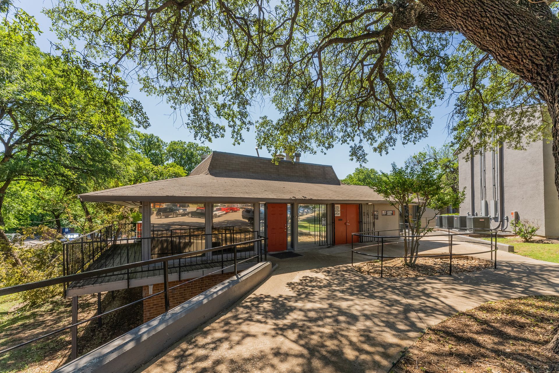 A large building with a roof that is covered in trees.