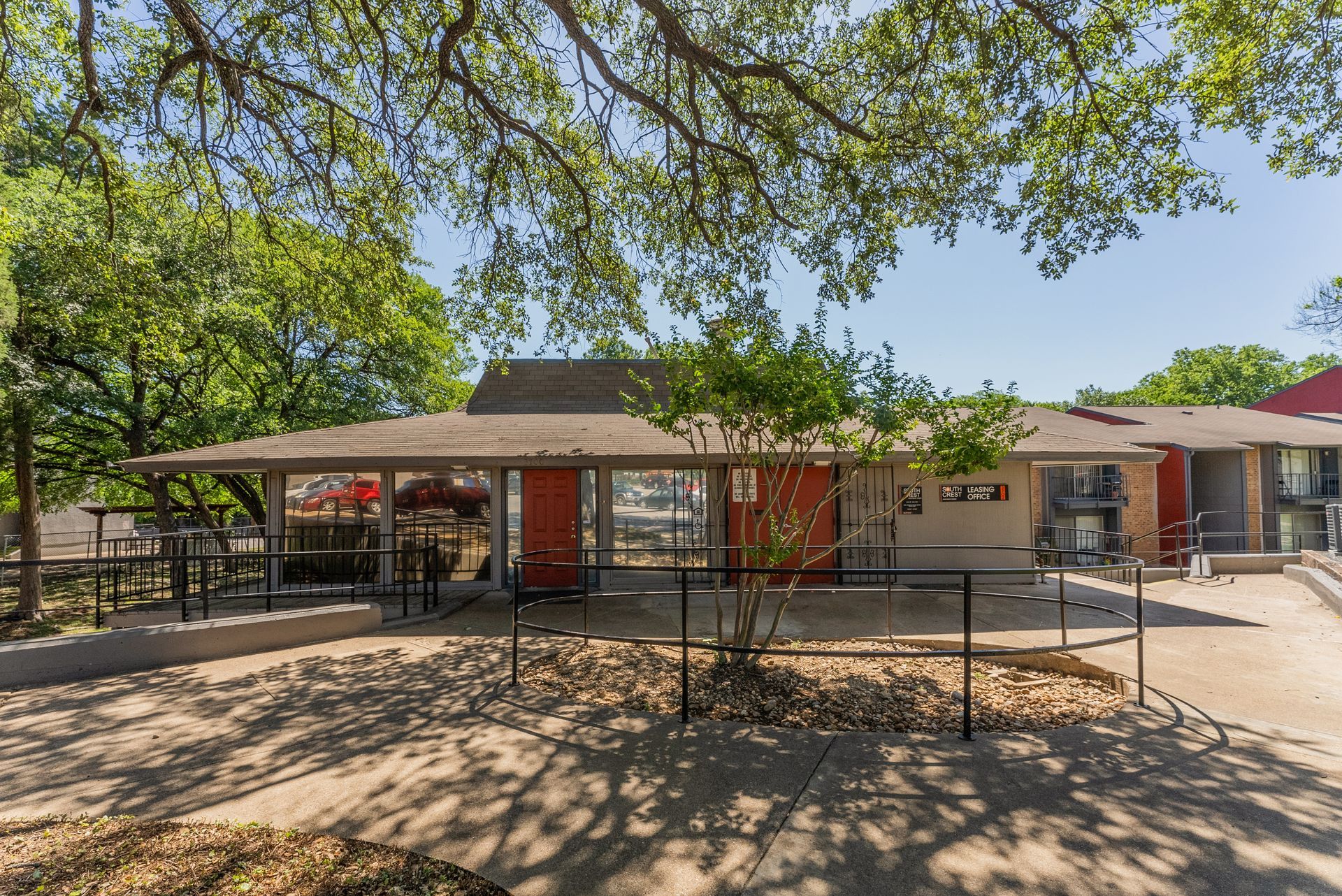 A house with a picnic table in front of it surrounded by trees.
