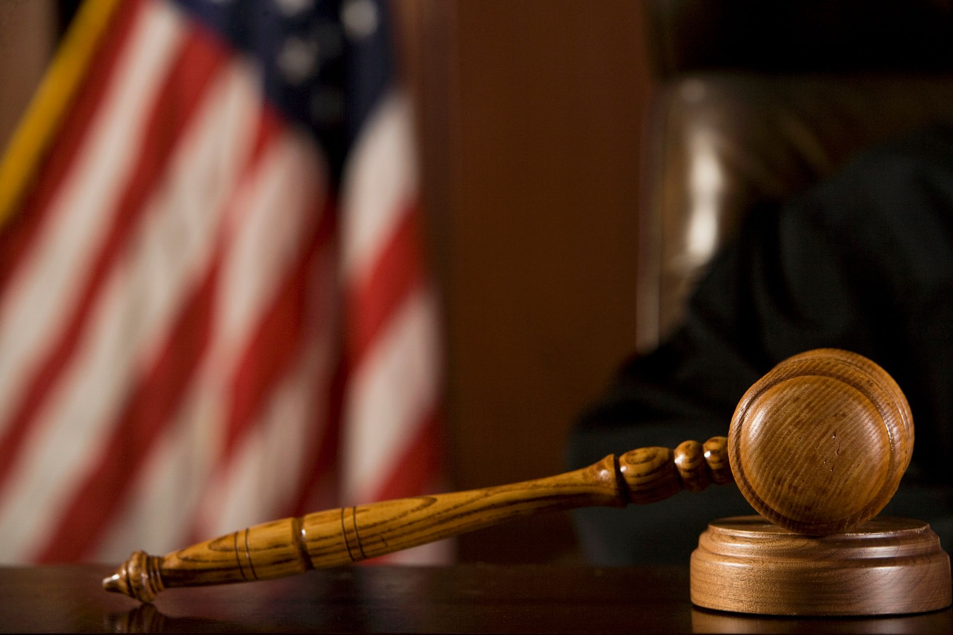 A gavel on a desk in front of an American flag, embodying the essence of justice and legal represent