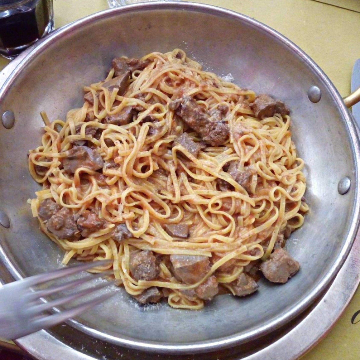 Una padella piena di pasta e carne con dentro una forchetta