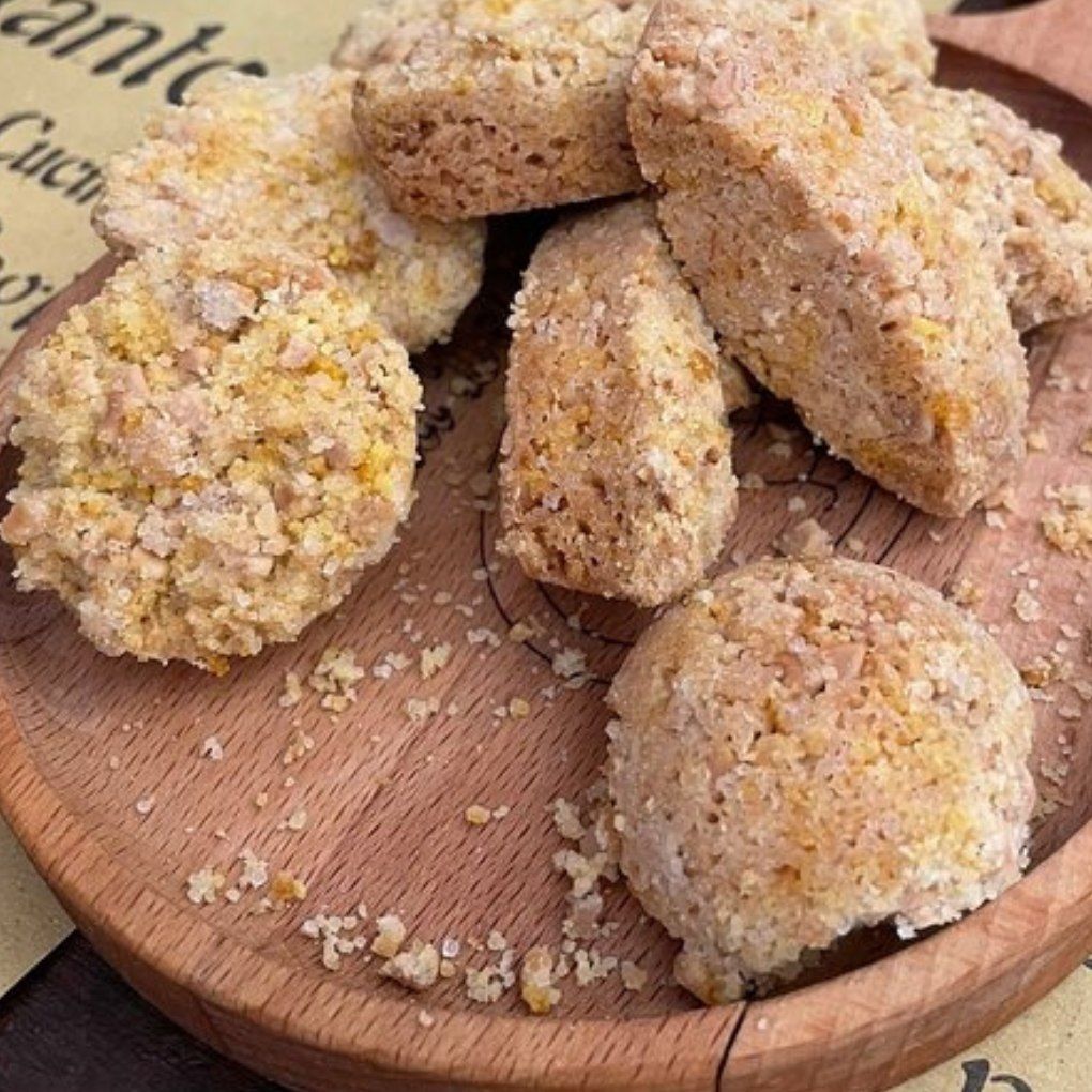 Un piatto di legno sormontato da un mucchio di biscotti e briciole