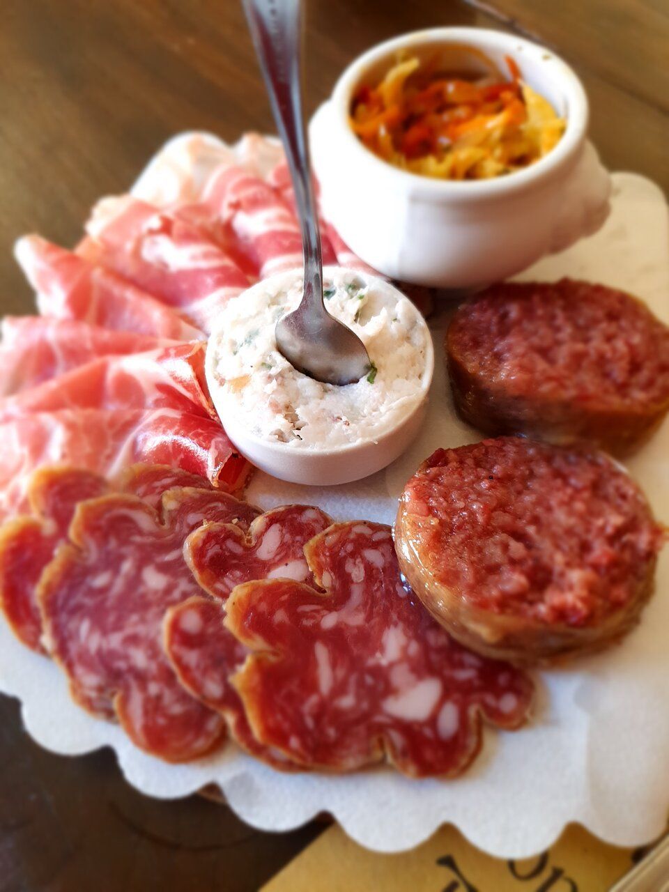 Un piatto di carne con una ciotola di salsa e un cucchiaio