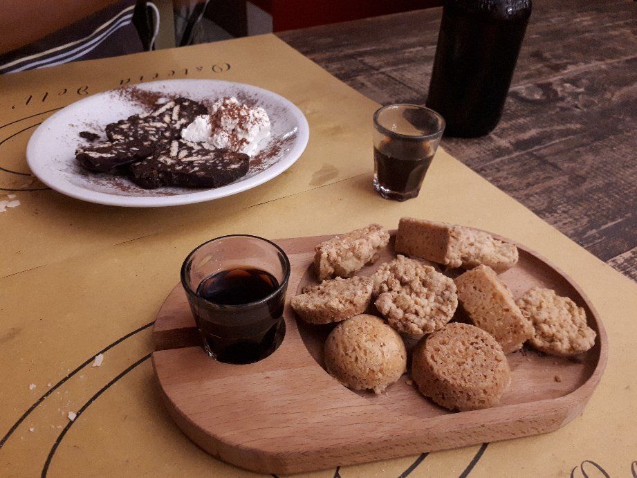 Un piatto di cibo e un bicchierino di caffè su un tavolo