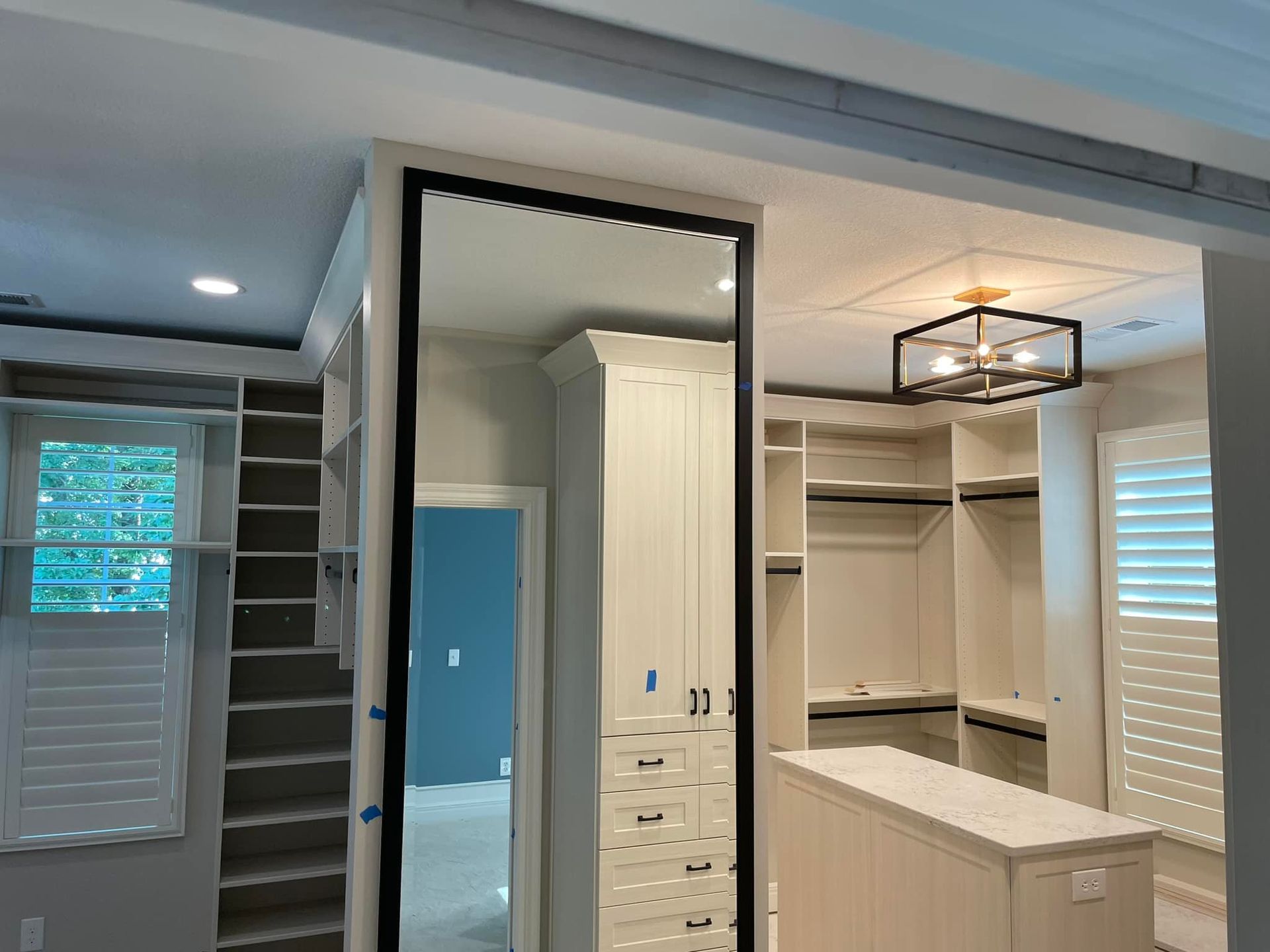A man is standing on a ladder working on a ceiling.