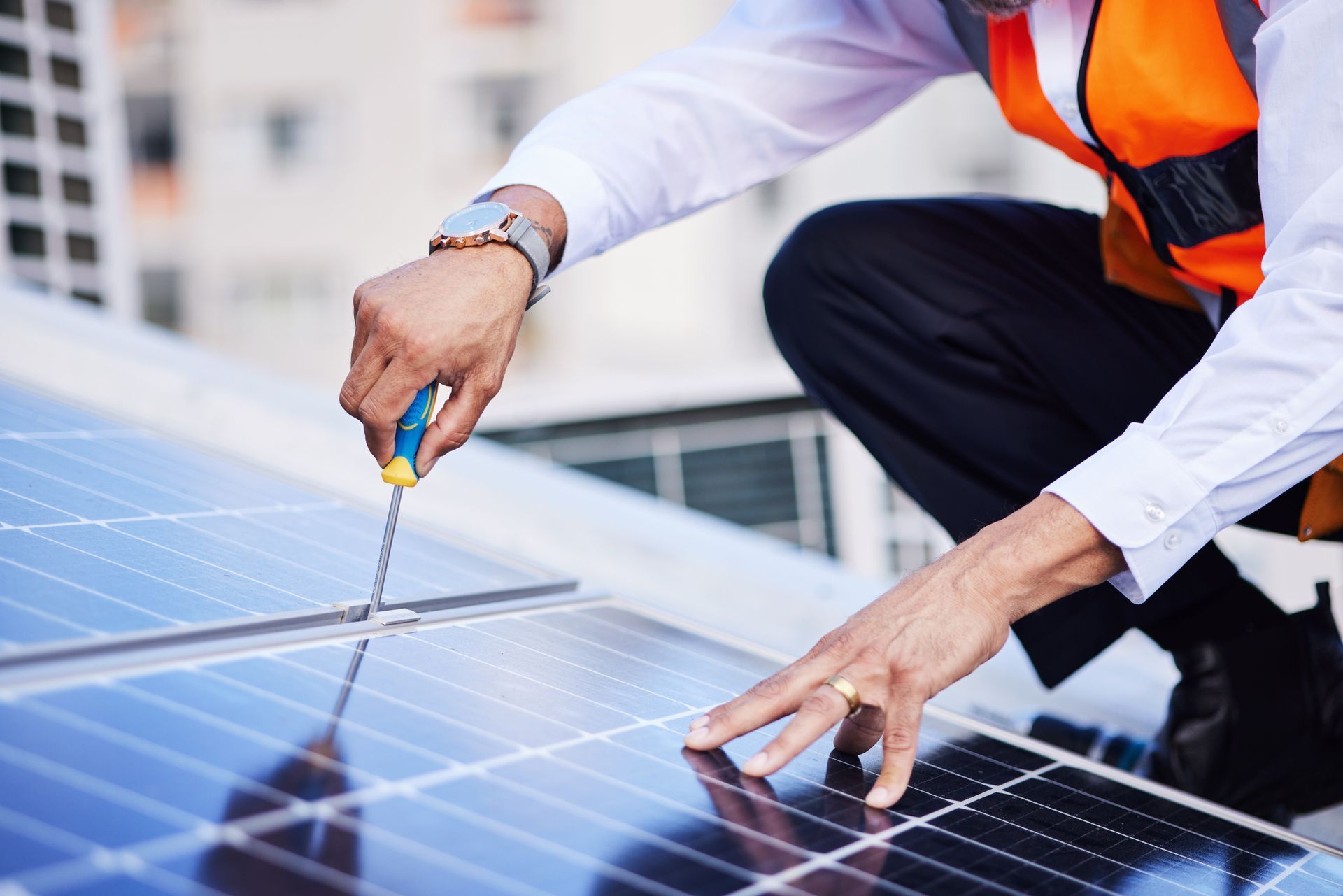 A man is working on a solar panel on the roof of a building.