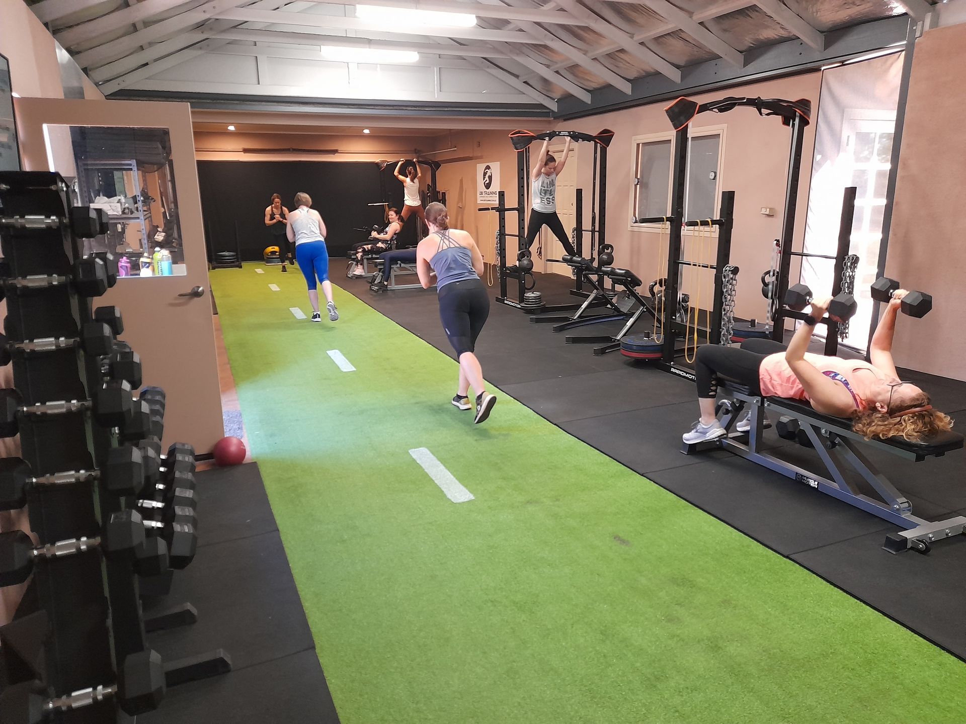 A woman is pushing a sled in a gym.