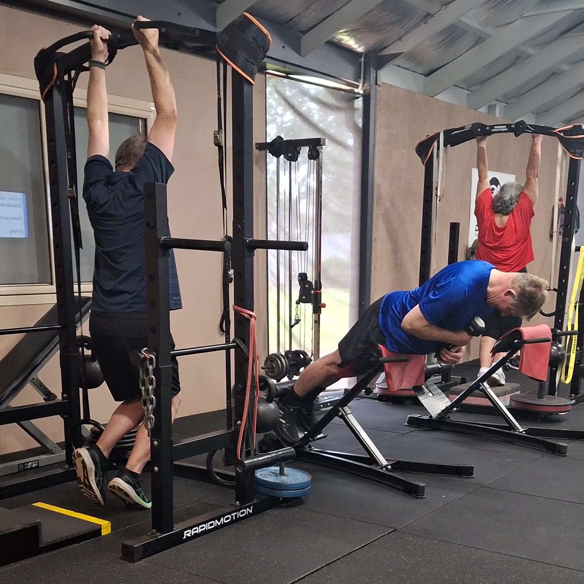 A woman is pushing a sled in a gym.