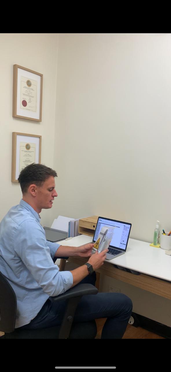 A woman in a blue apron is standing in front of a table.