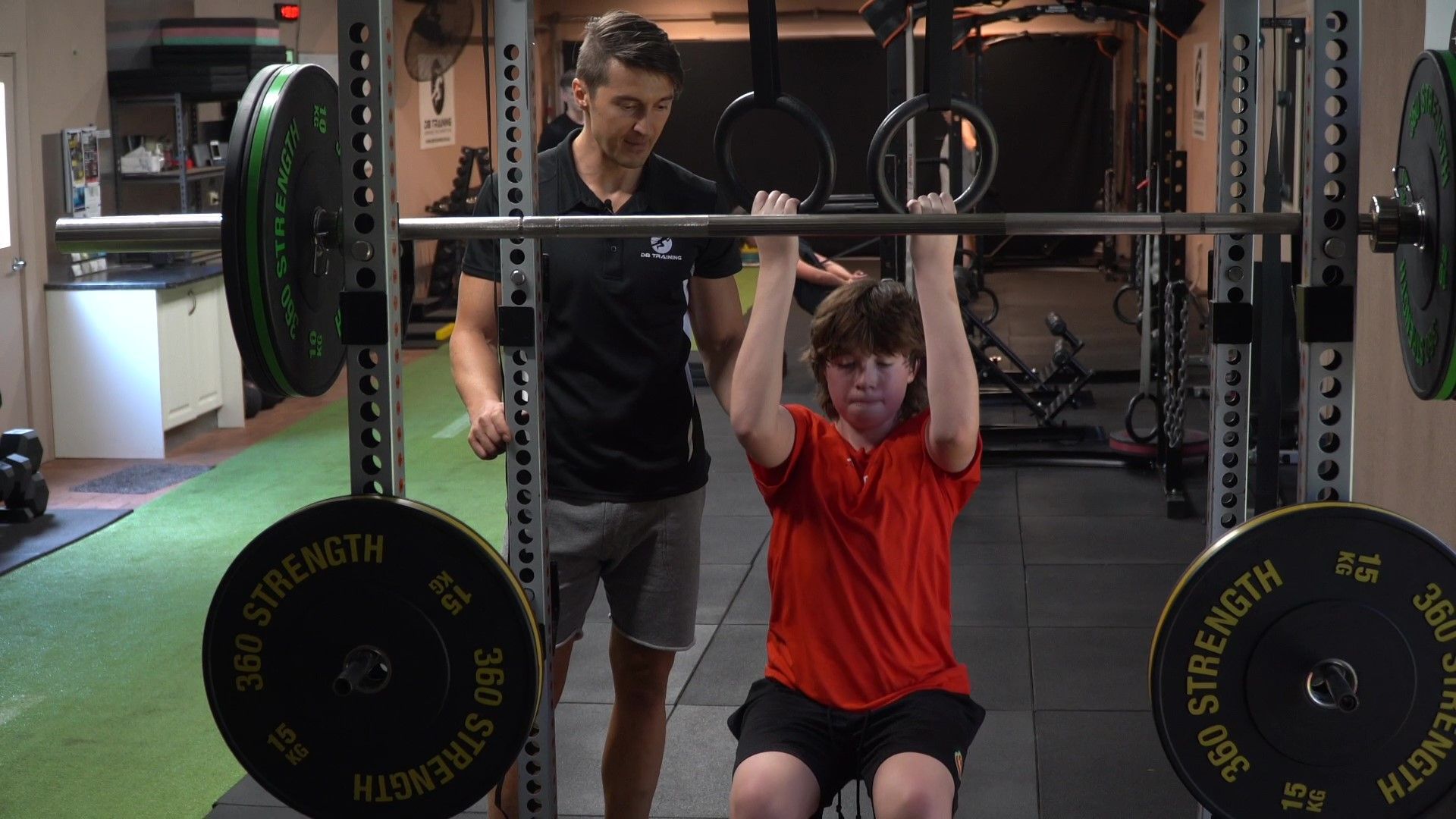 A woman is pushing a sled in a gym.