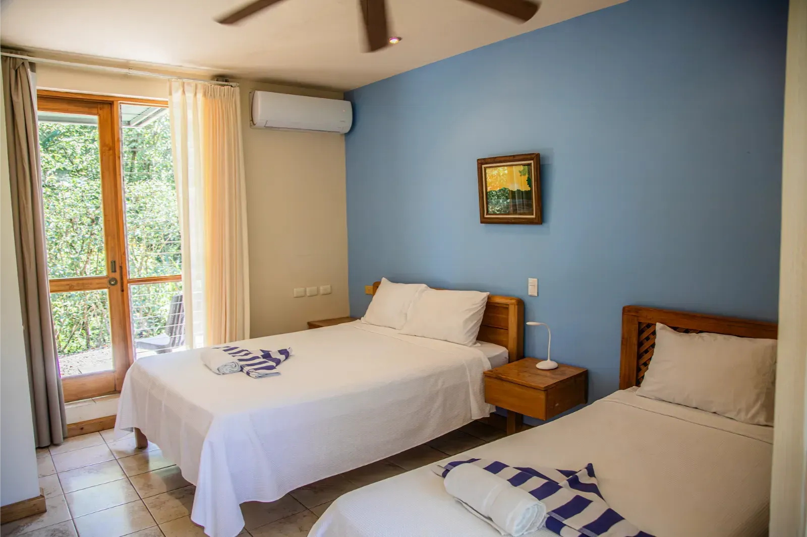 Bedroom with two twin beds, blue walls, and a door to the outdoors.