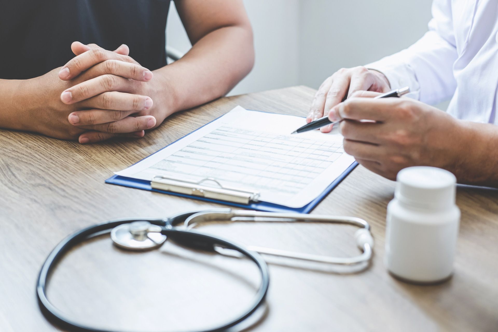 A doctor is talking to a patient while sitting at a table.