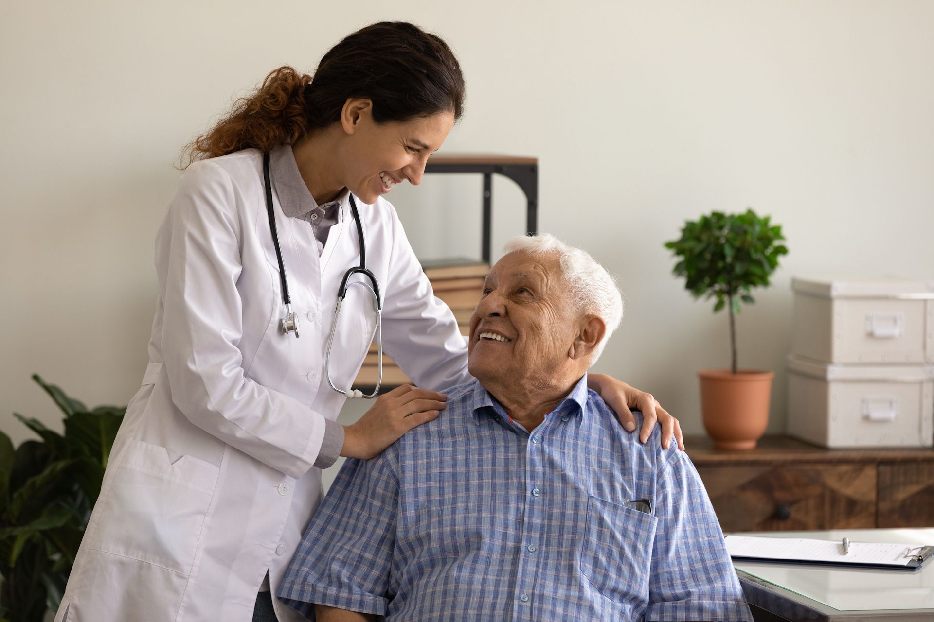 A doctor is talking to an elderly man in a wheelchair.