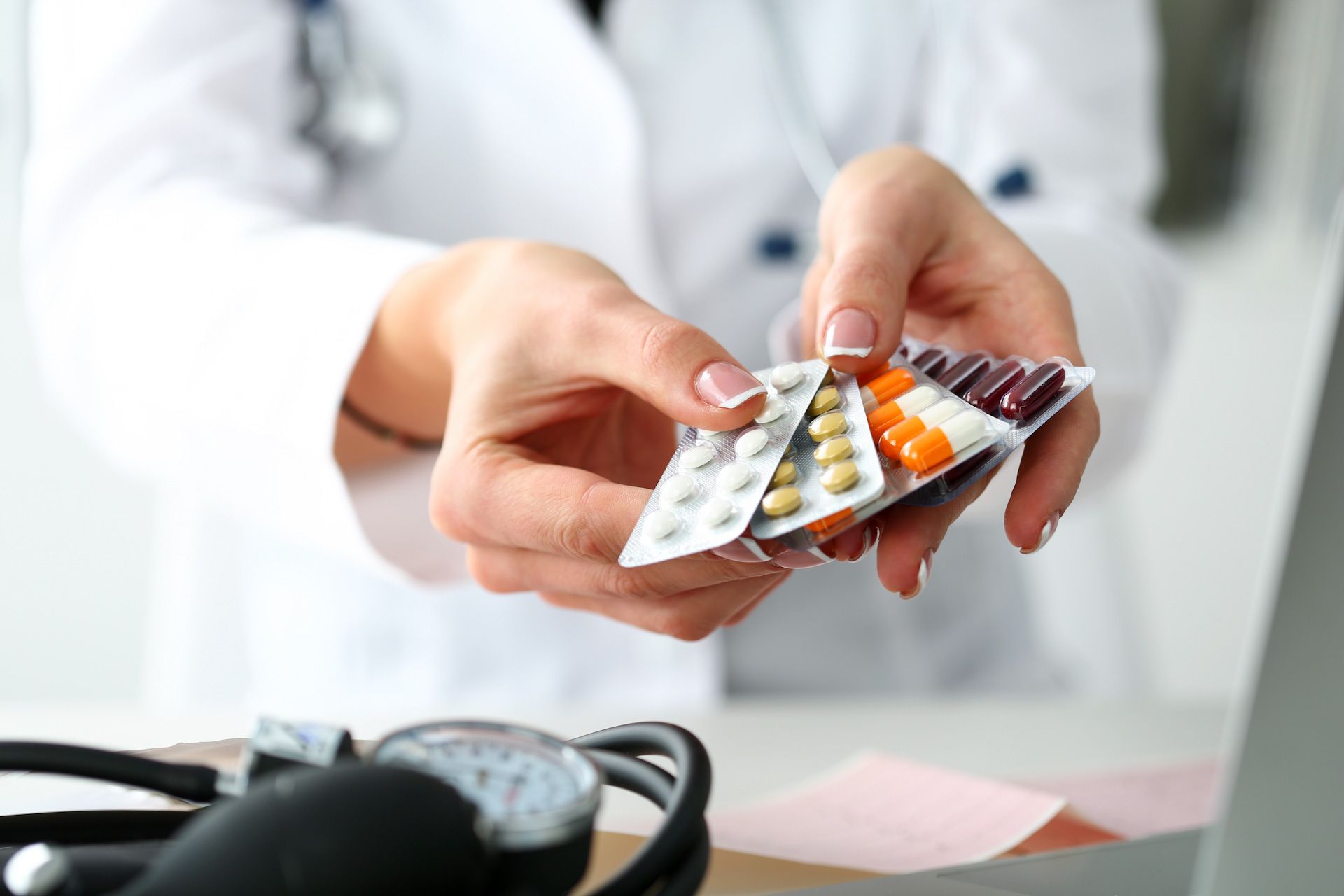 A doctor is holding a blister pack of pills in her hands.