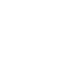 Close-up of a person's hand holding a round, white wooden craft shape against a blurred indoor background.