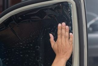 Applying Tinting Foil on a Car Window — Window Tinting in Elk Grove, CA