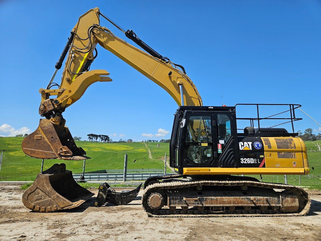 A red excavator is digging a hole in the dirt.