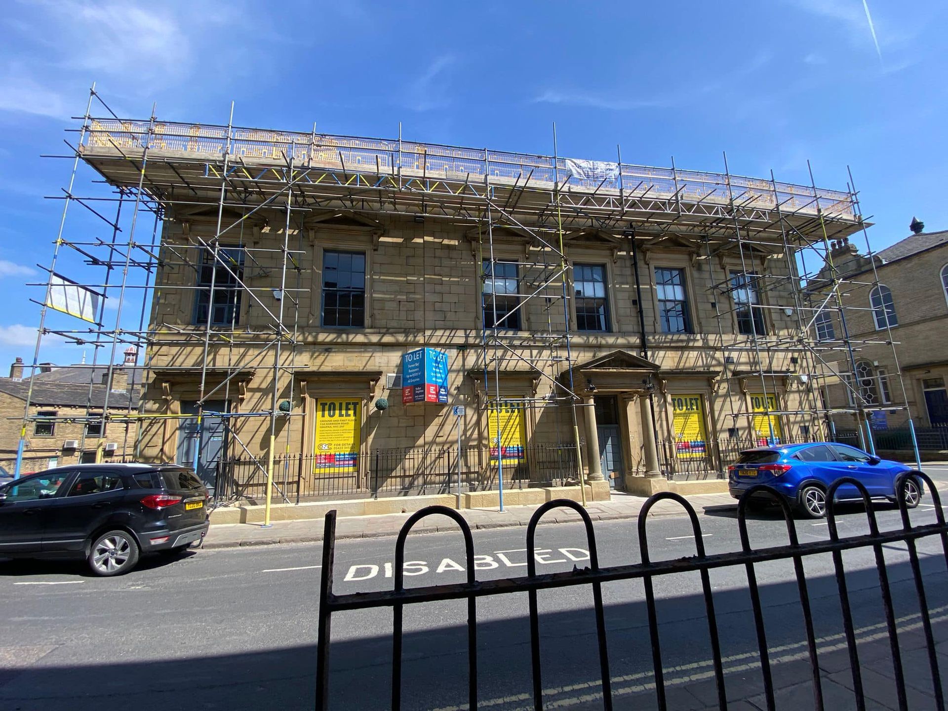 A large building with scaffolding on it is being remodeled.