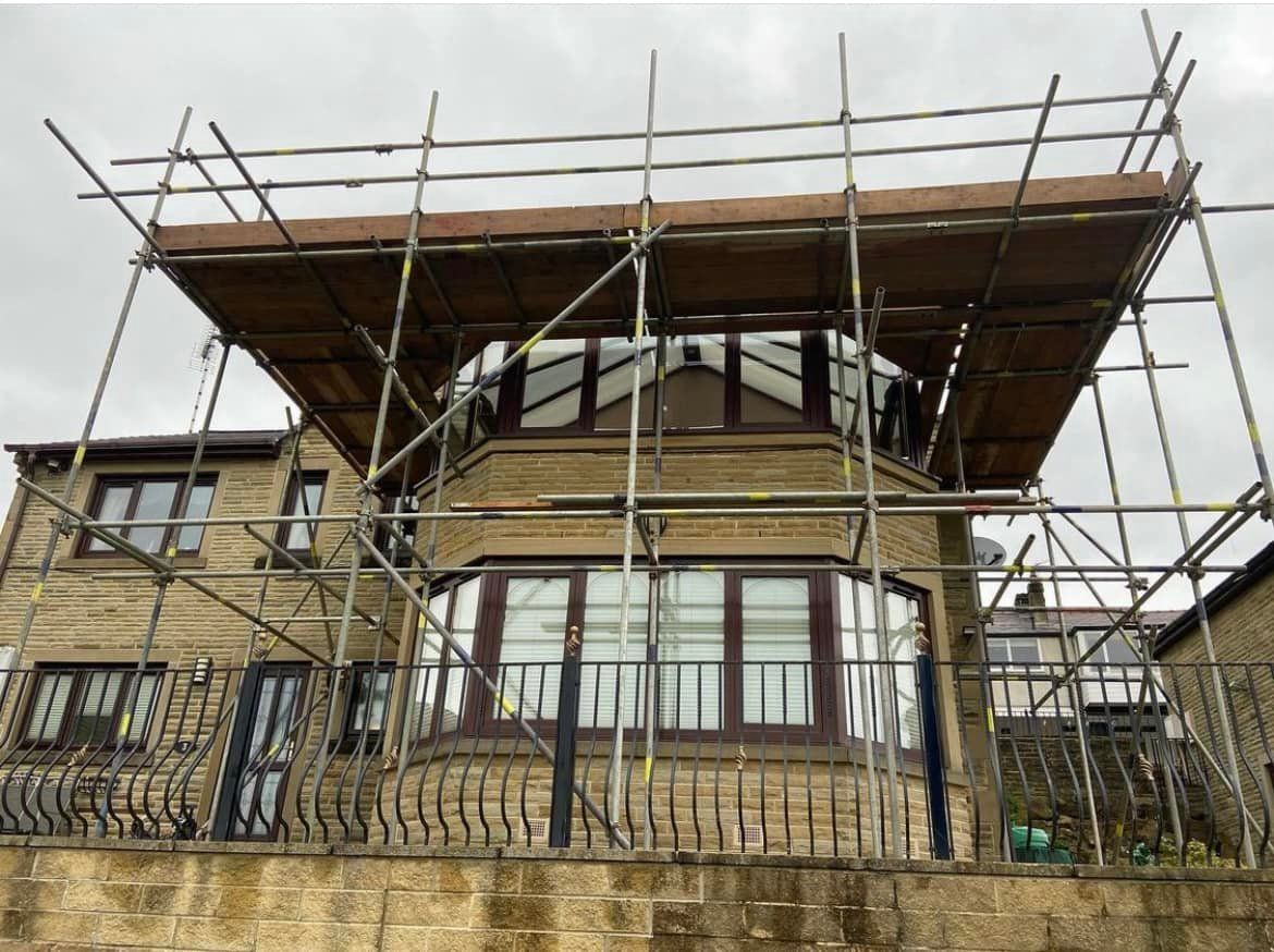 A house with scaffolding around it and a balcony.