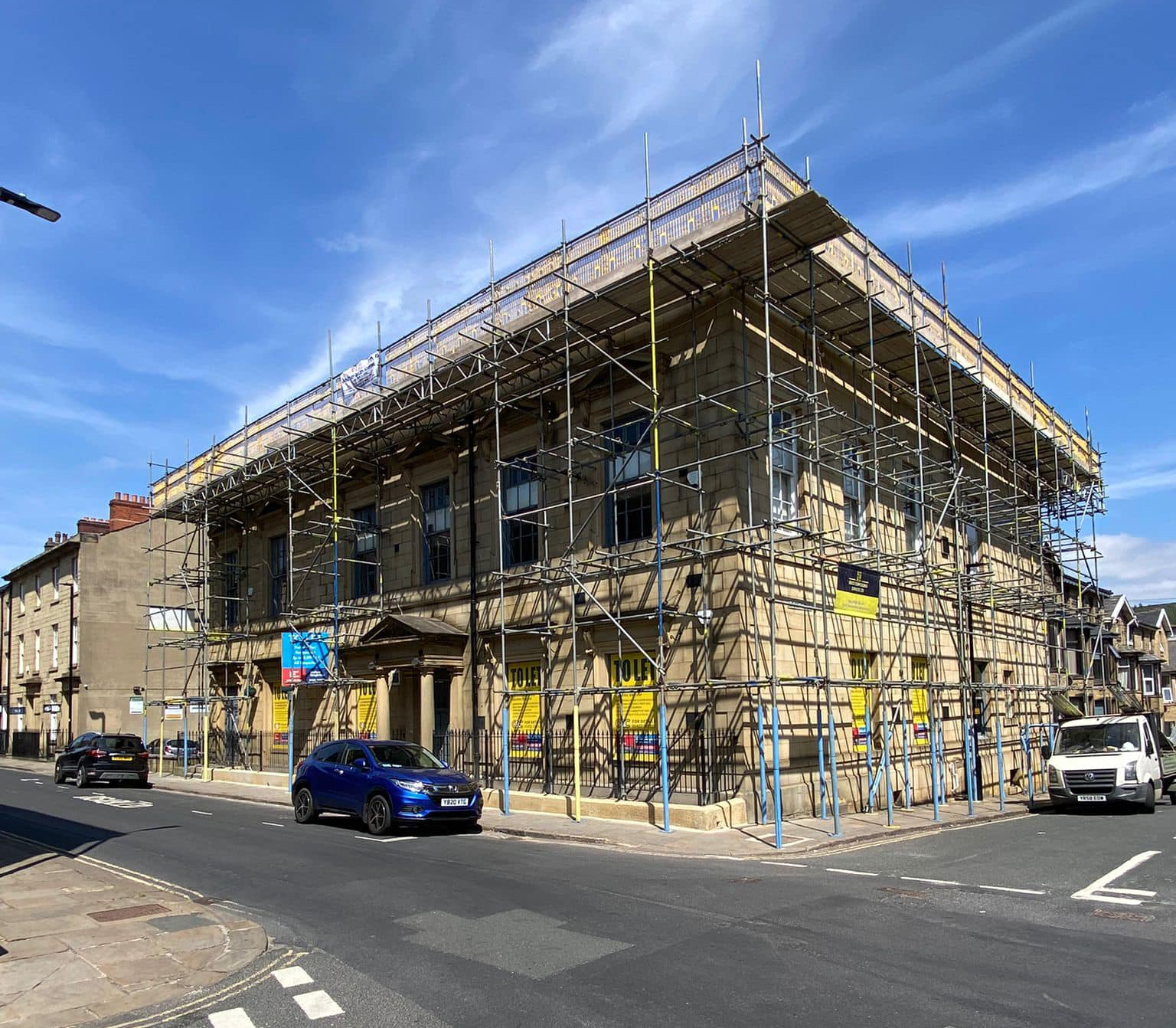 A large building with scaffolding on it is being remodeled.