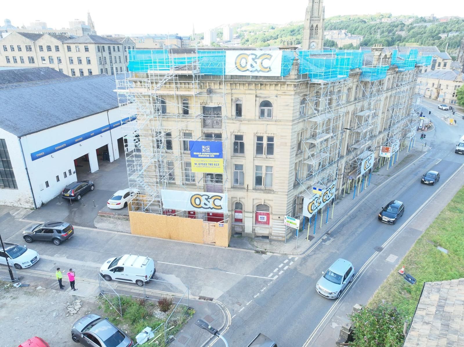 An aerial view of a building under construction with cars parked in front of it.